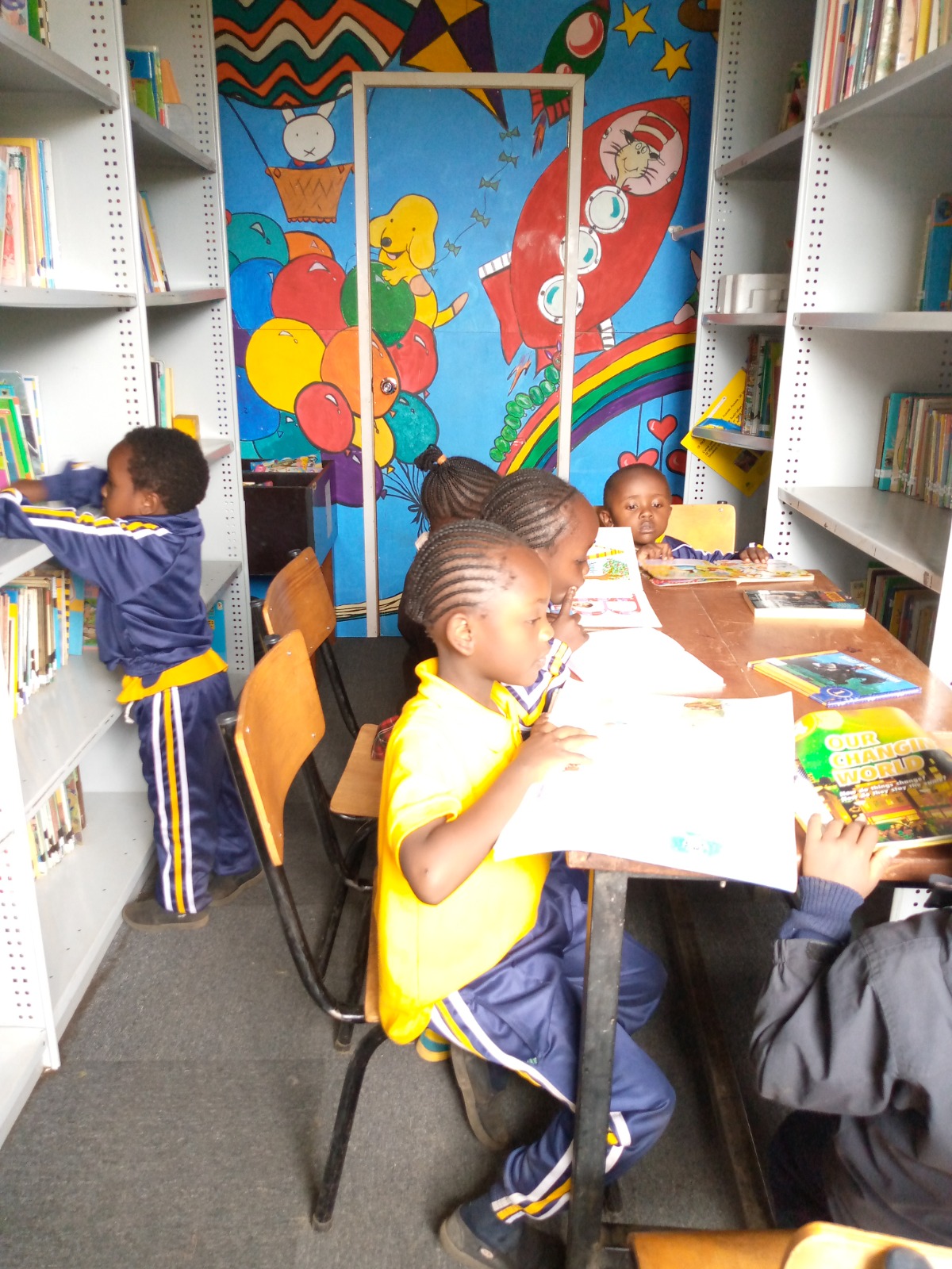 Story time beside the library mural